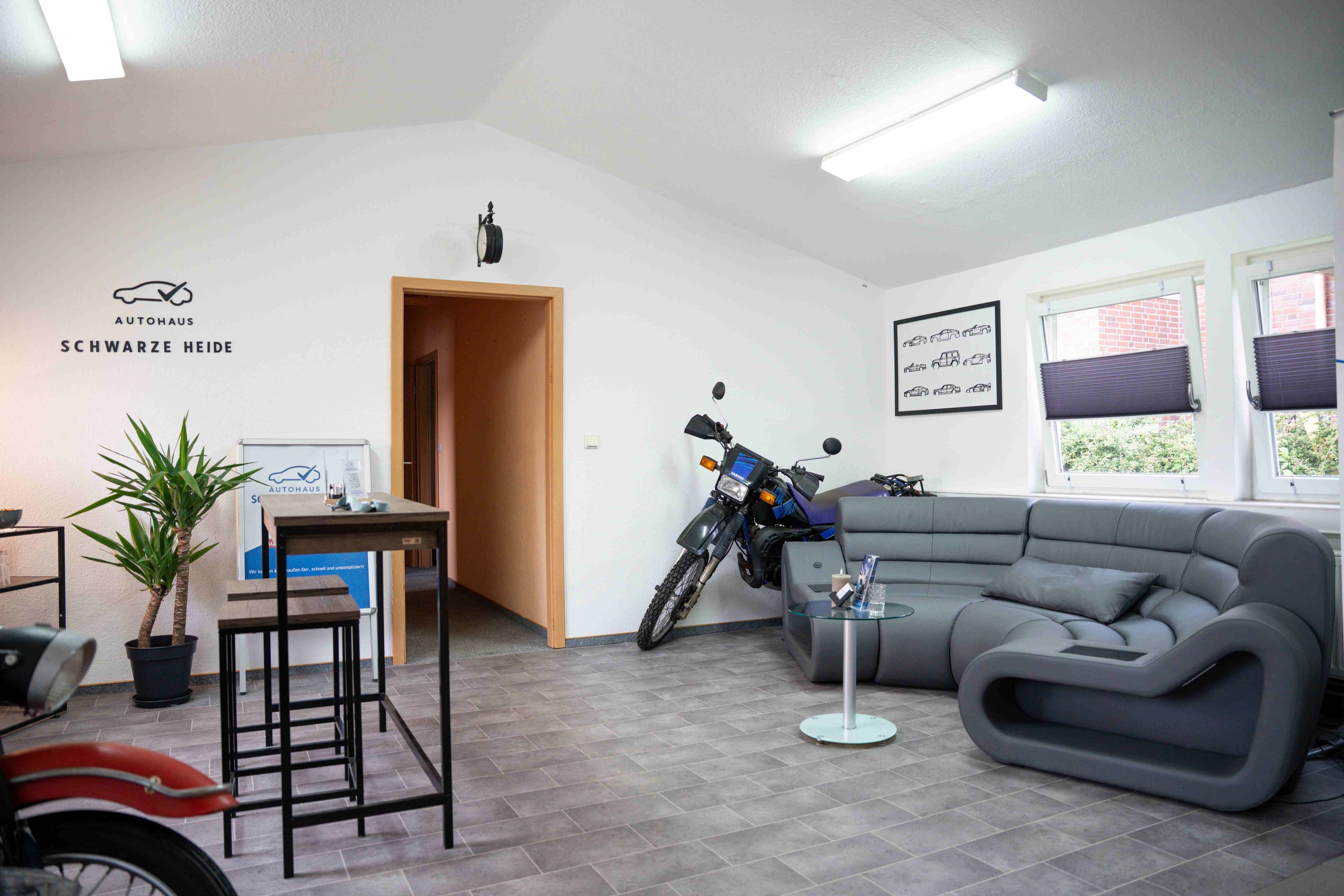 Empfangs- und Loungebereich mit Sofa und Oldtimer-Motorrad